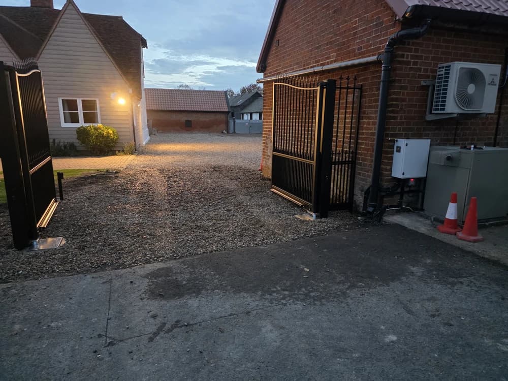 Side view of black metal estate gates over block paving