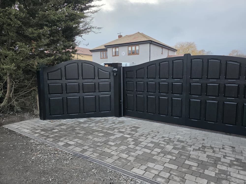 Black timber raised-panel gates with an arched top