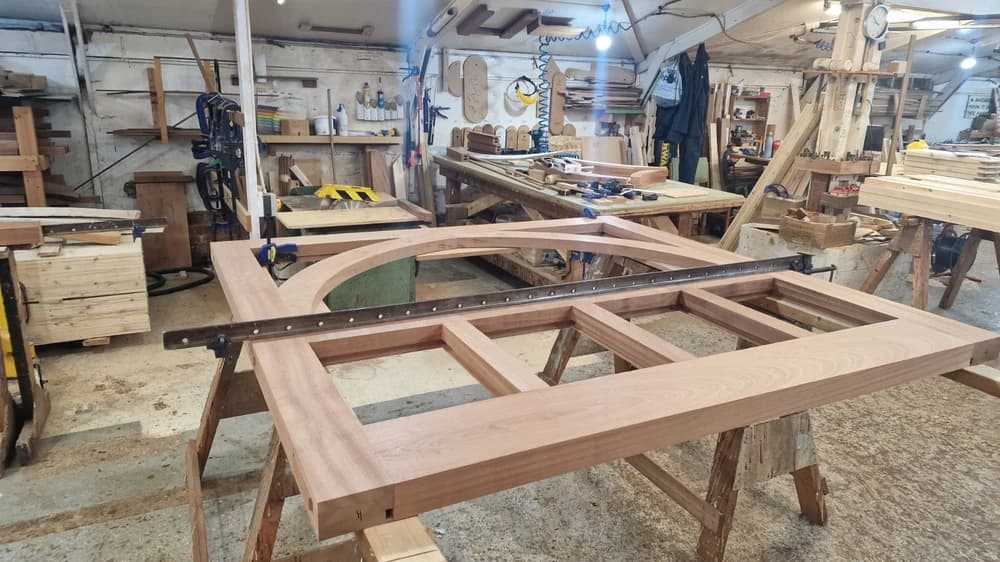 Curved hardwood gate frame being built up in the workshop