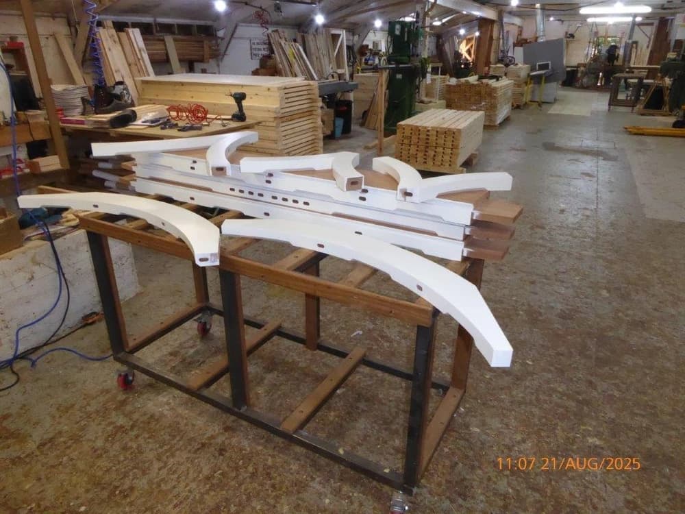 Curved-top hardwood profiles laid out in the workshop